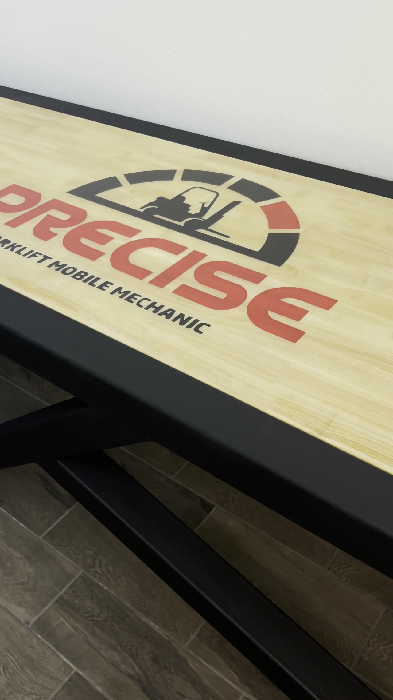 Custom fabricated steel-frame table with a wood top branded for a forklift mobile mechanic