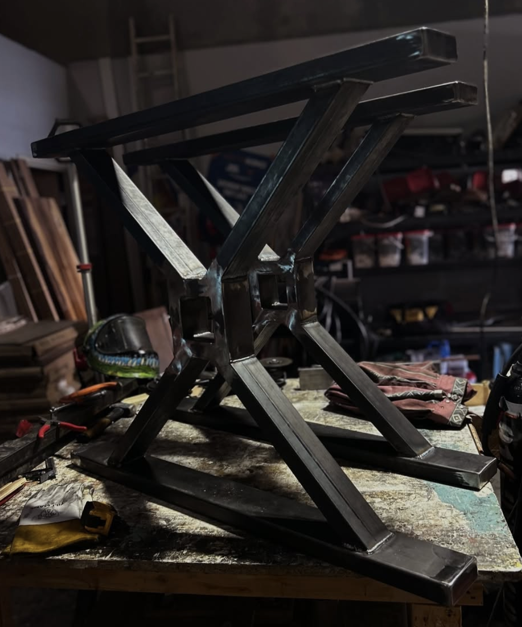 Custom welded steel trestle table base on the shop bench